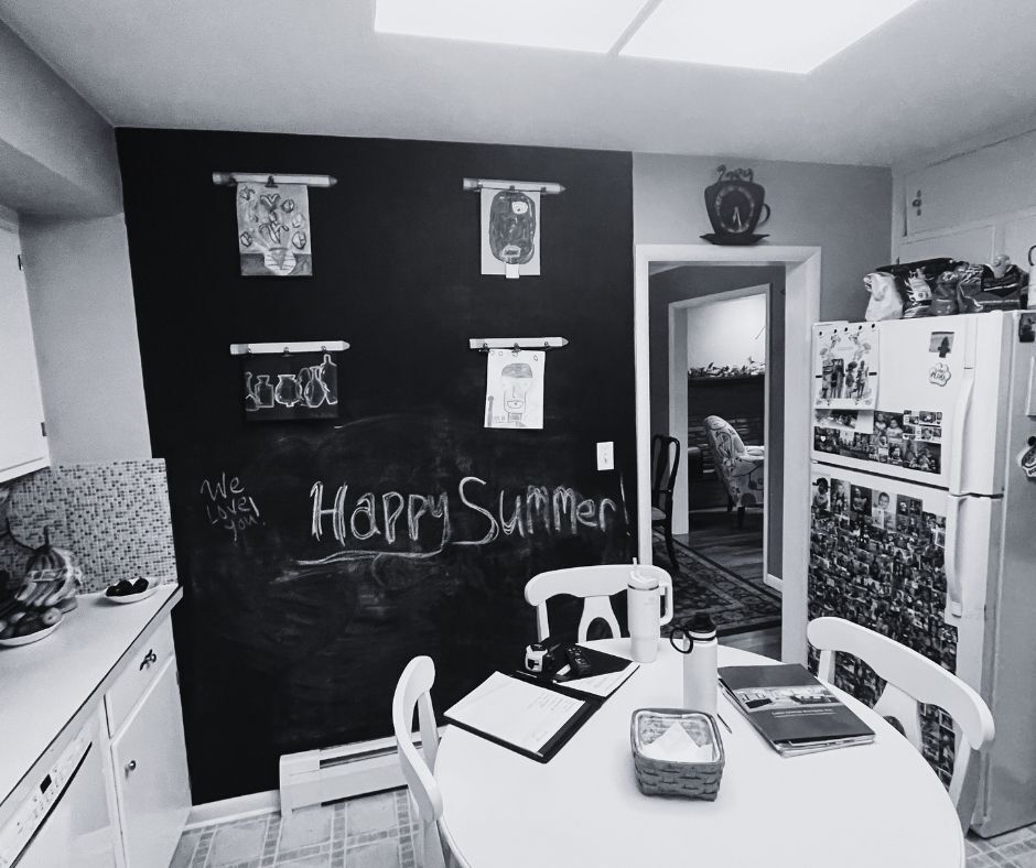 Outdated Bethlehem PA kitchen with chalkboard wall, white cabinets, and photo-covered refrigerator before Laslo Custom Kitchens remodel.