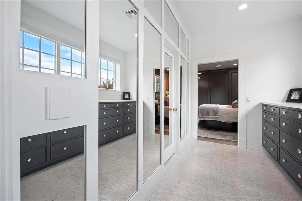 Black built-in drawers in a closet are reflected in a mirror. Closet by Laslo Custom Kicthens.