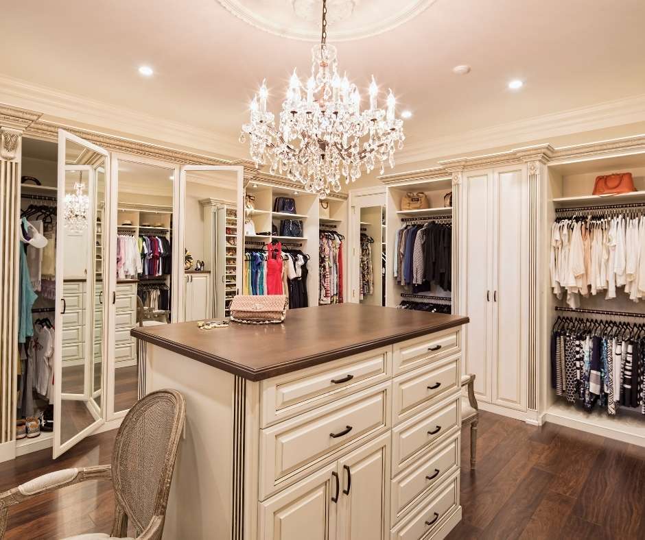 Closet with center drawers and a chandelier.