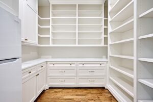 Walk-in pantry with white Fabuwood cabinets.