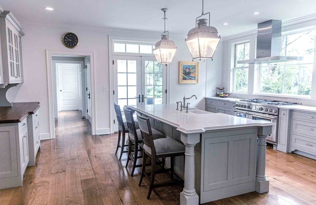 A kitchen with a large island and chairs