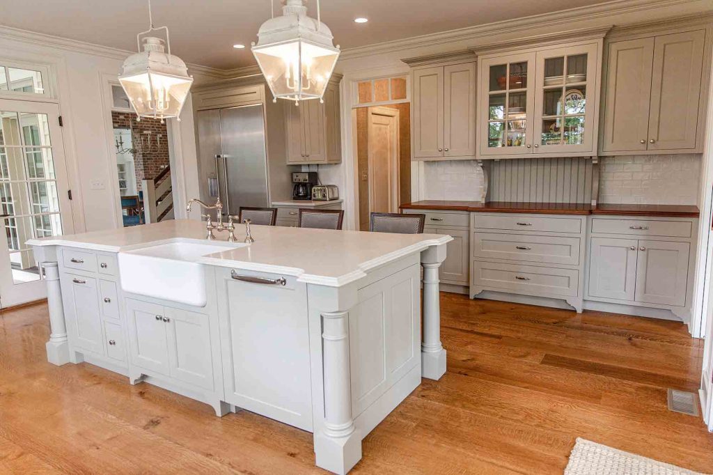 A kitchen with white cabinets and a large island