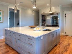 A kitchen with a large island by Laslo Custom Kitchens.