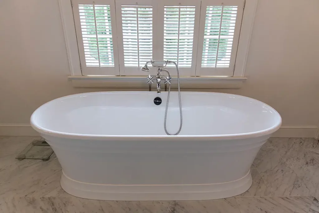 soaking tub in bathroom remodel with marble tile floor