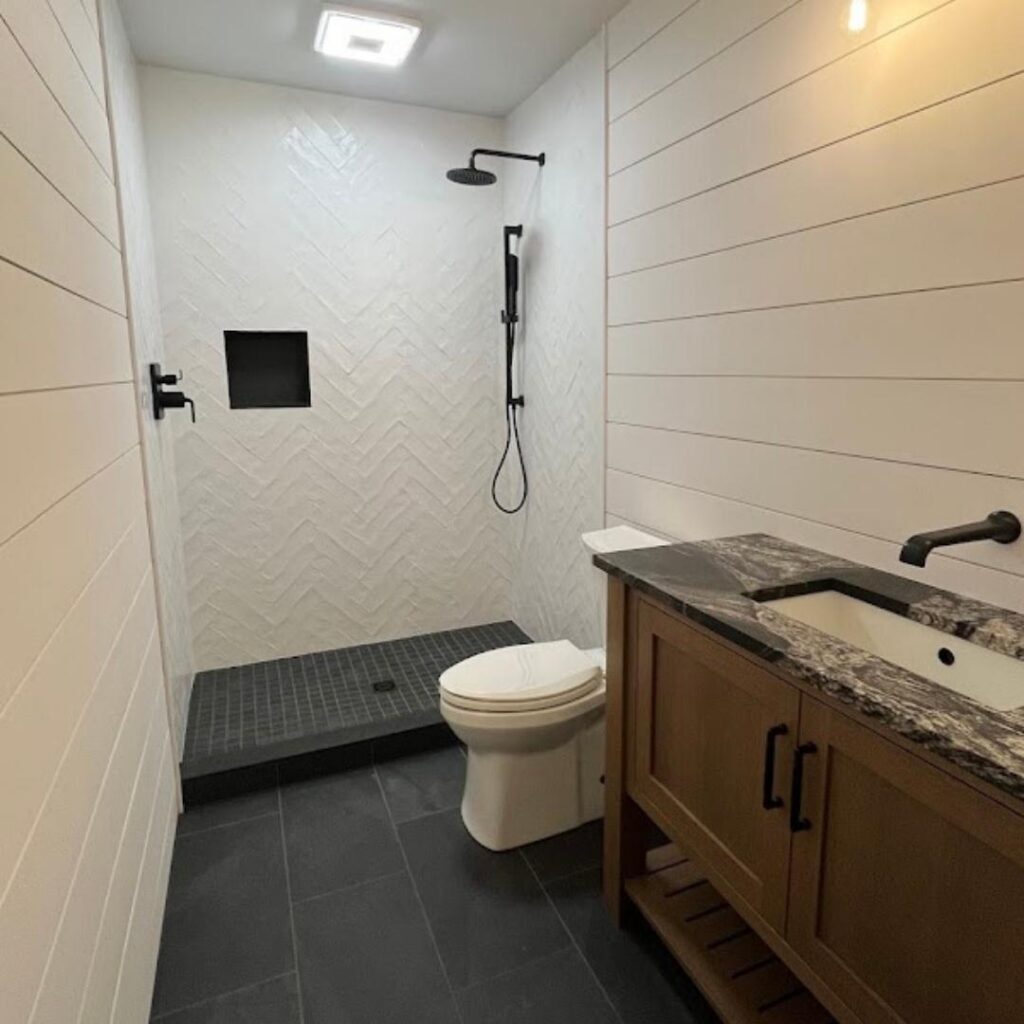 A bathroom with an oak vanity and open shower.