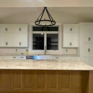 White oak island in a kitchen with white cabinets.