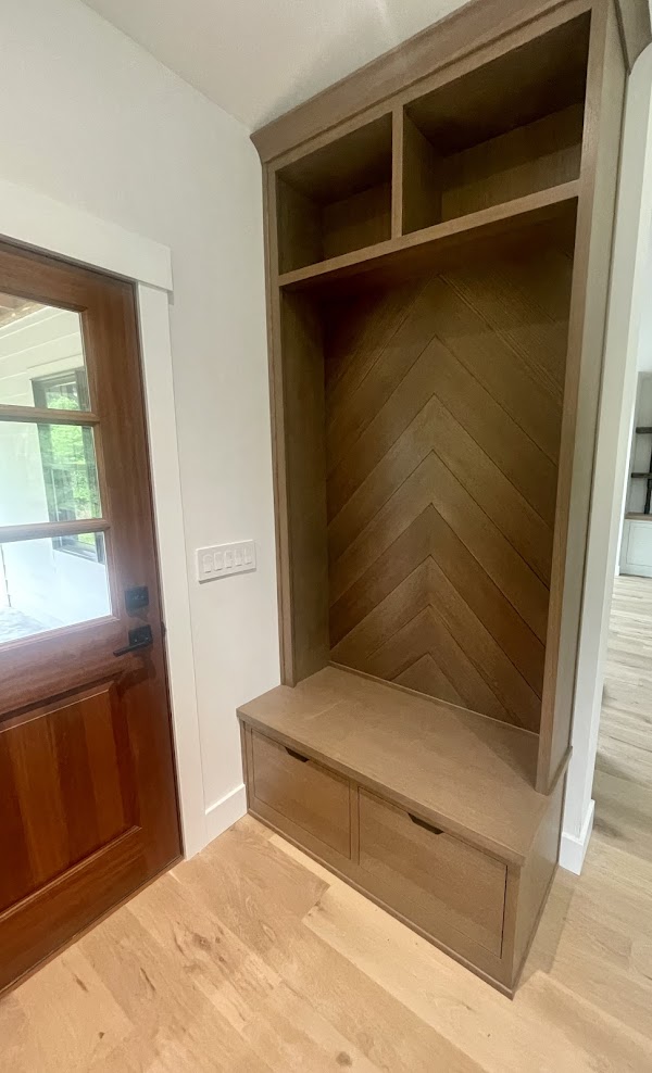 A white oak mudroom storage area by the front door.