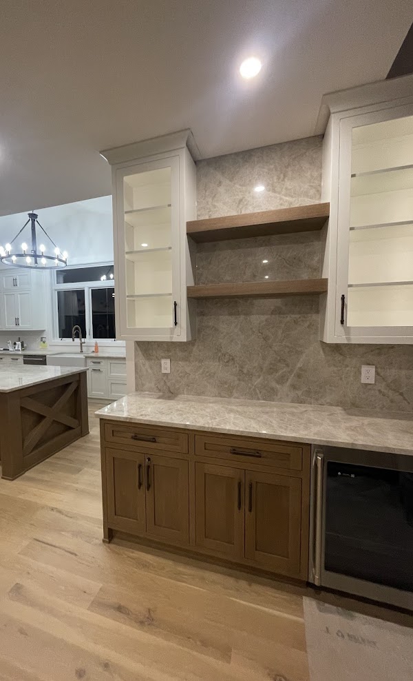 A white oak wet bar with white cabinets.