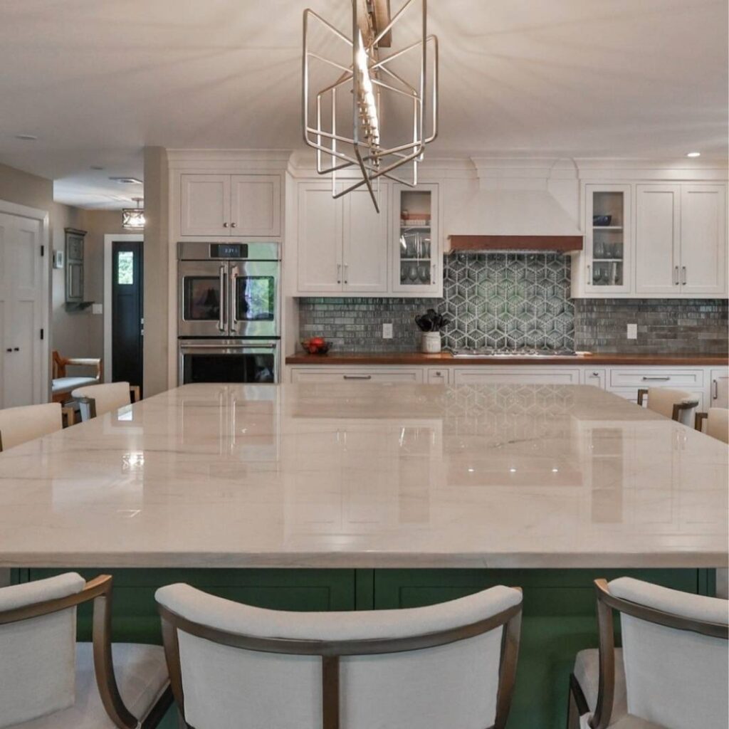A kitchen with light maple cabinets and a green island.