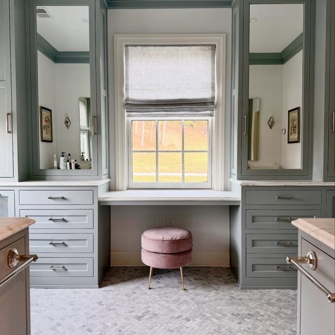 a primary bathroom with marble countertops, mosiac stone floor and Benjamin Moore Painted cabinetry