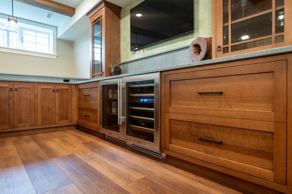 Basement bar with integrated appliances and custom cabinetry