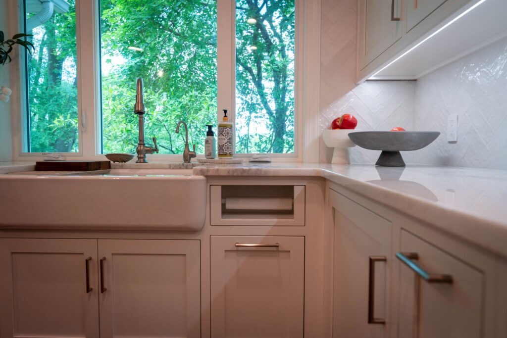 paper towel holder built into cabinetry next to a farmhouse sink