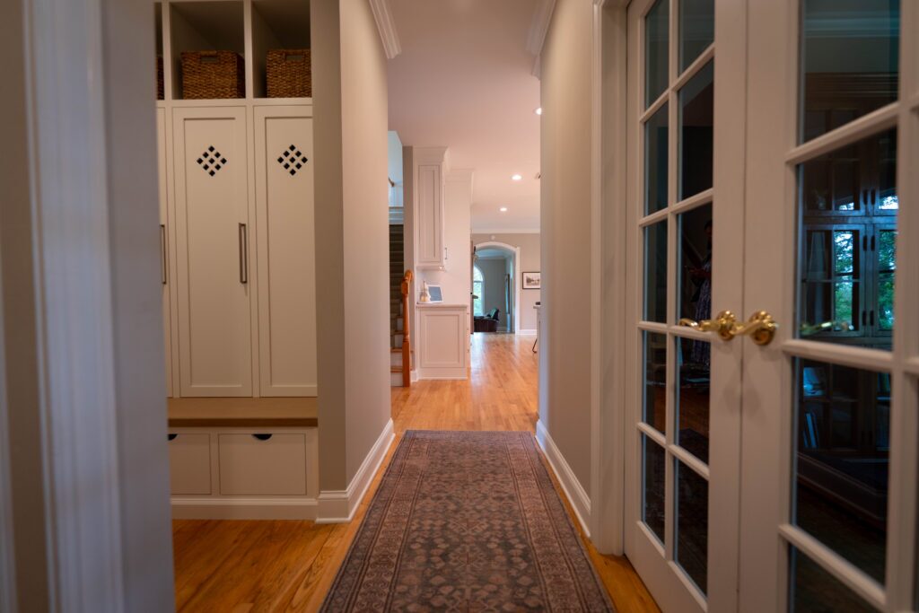 hallway view of a white entry way coat and backpack storage with bench in center valley pa