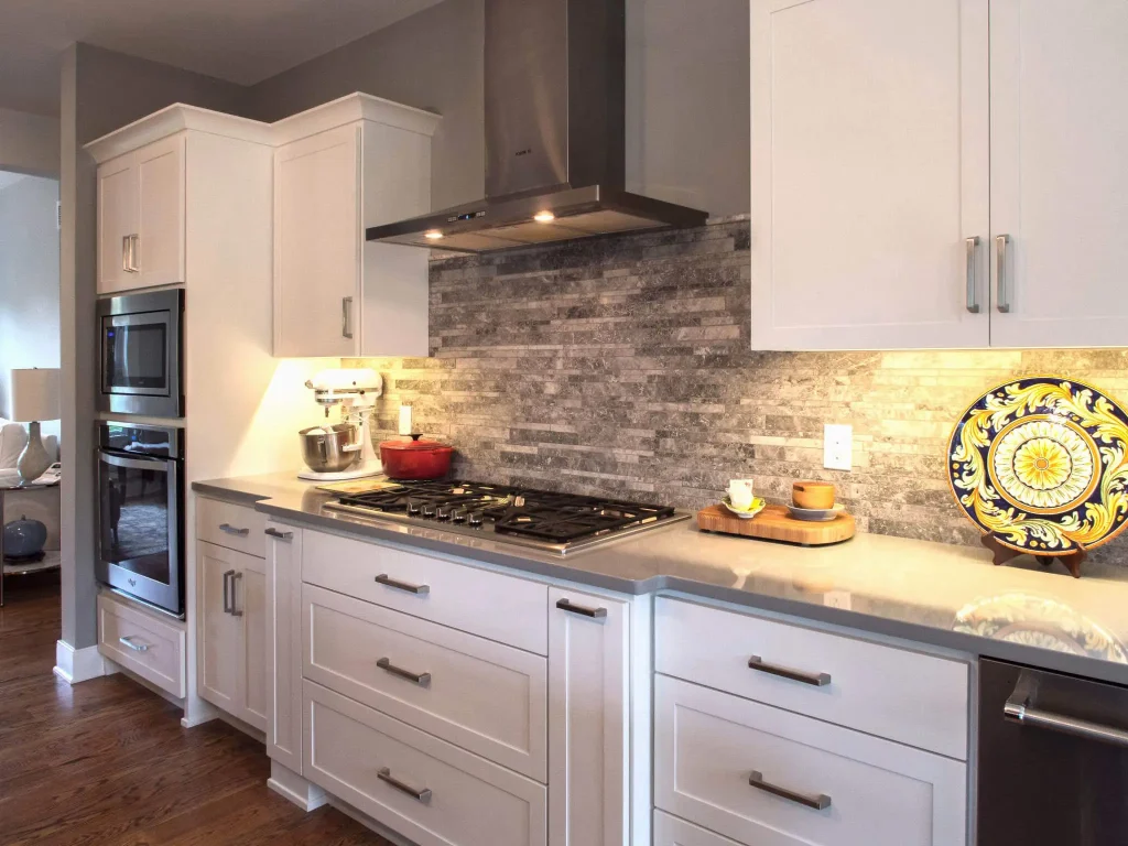 A kitchen with white cabinets and a stove