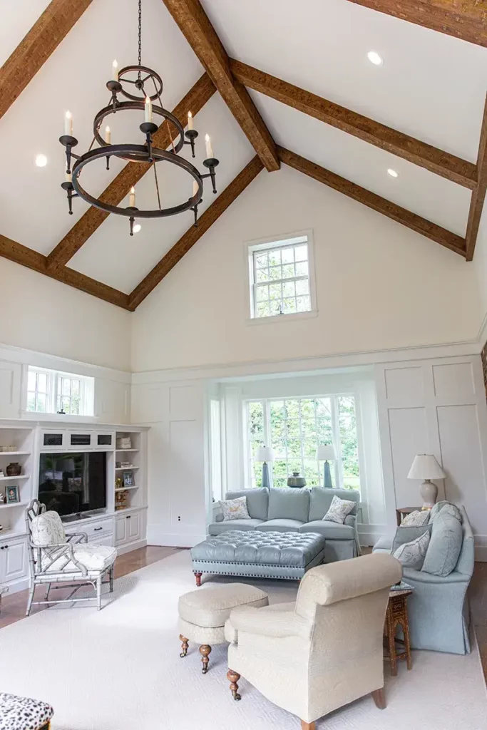 Tall cathedral ceilings and a unique light fixture that has a classic style and candle like lighting suspended from the ceiling.