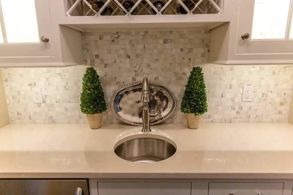 Small oval sink with stone tile backsplash