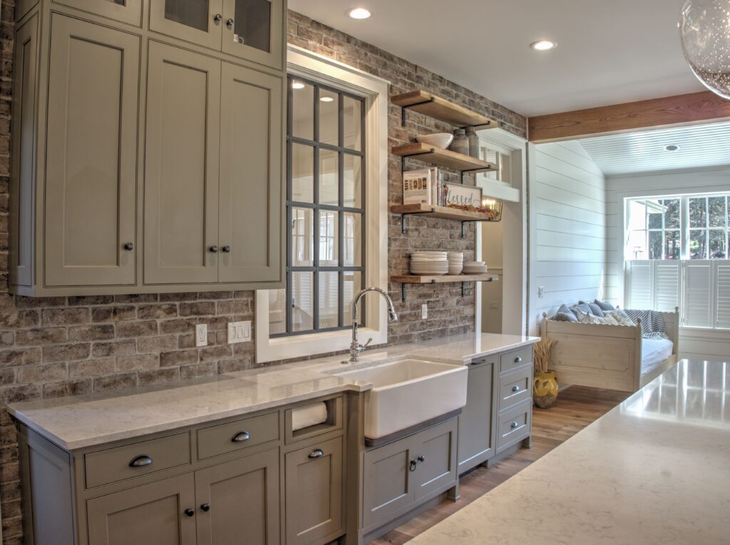 kitchen with white countertops and a farm sink with green cabinetry