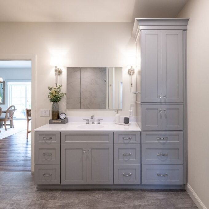 A bathroom with gray vanity and storage cabinets. Designed for a Hellertown bath remodel by Laslo Kitchens