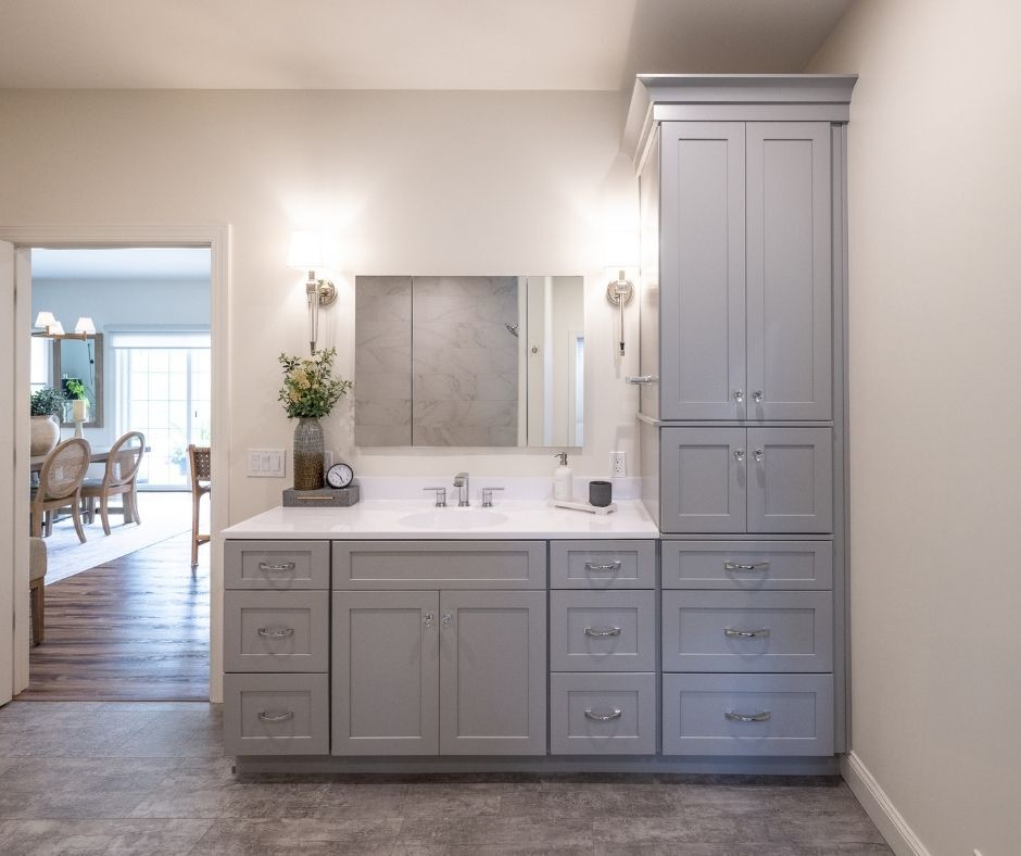 A bathroom with gray vanity and storage cabinets. Designed for a Hellertown bath remodel by Laslo Kitchens
