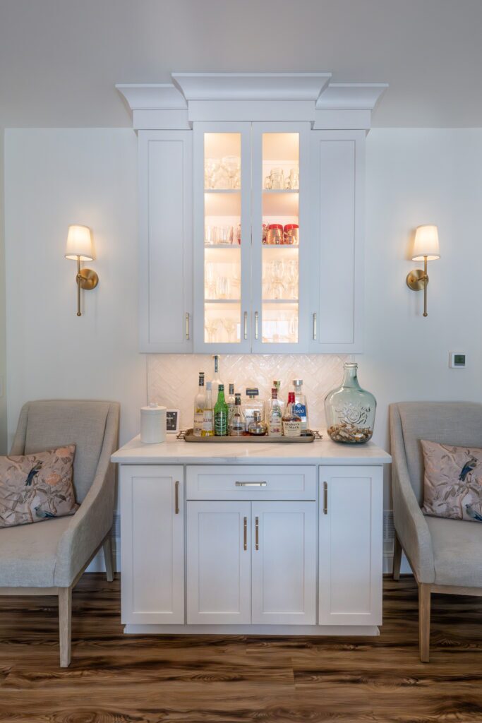 A white beverage nook flanked by 2 gray chairs.