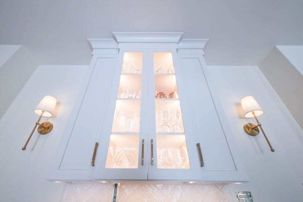 Glass cabinets with lighting highlight a beverage nook.