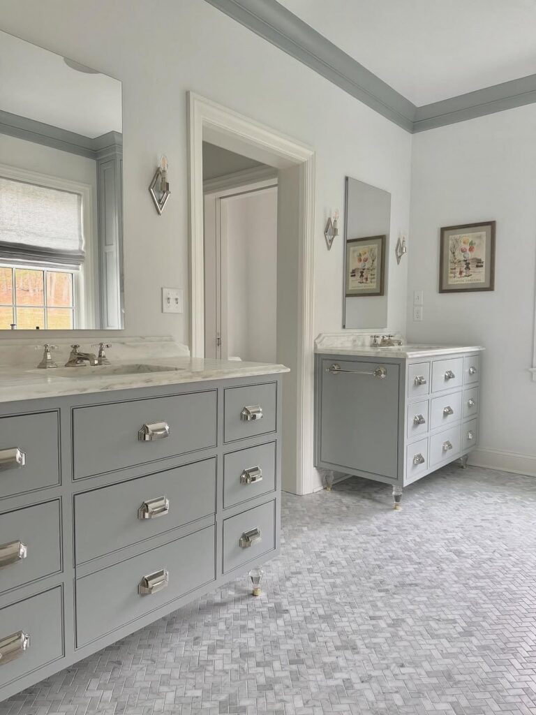a bathroom remodel in orefield, pa with kohler nickel faucets in the pinstripe model, marble countertops, inset twin vanities and stone mosiac floor in a herringbone pattern