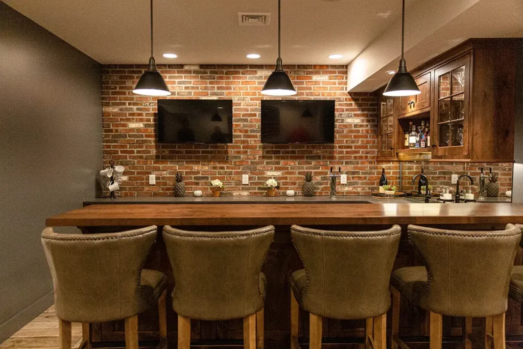 comfortable seating and TV screens for entertaining in a custom bar by Laslo Custom Kitchens 