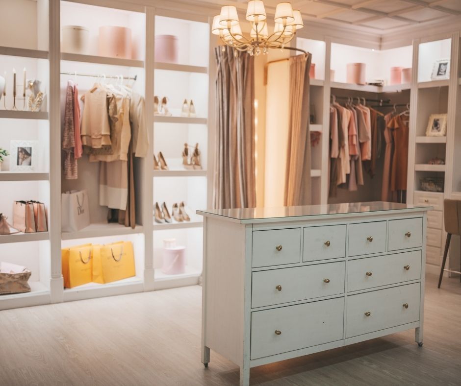 Closet with cabinet lighting and a chandelier.