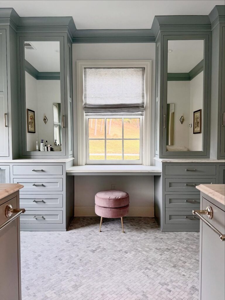 a primary bathroom with marble countertops, mosiac stone floor and Benjamin Moore Painted cabinetry