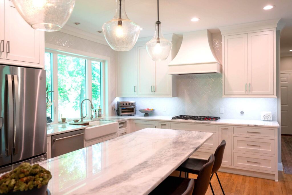 A sophisticated cooking space crafted by luxury custom cabinetry installers, showcasing a magnificent custom wood-paneled range hood and elegant stone countertops.