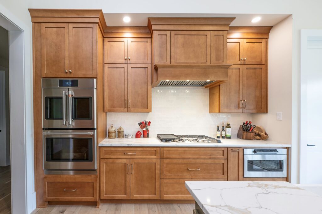 A wide view of the completed kitchen remodeling project in Bethlehem, PA, featuring hard maple cooking wall cabinetry and built-in stainless steel appliances.