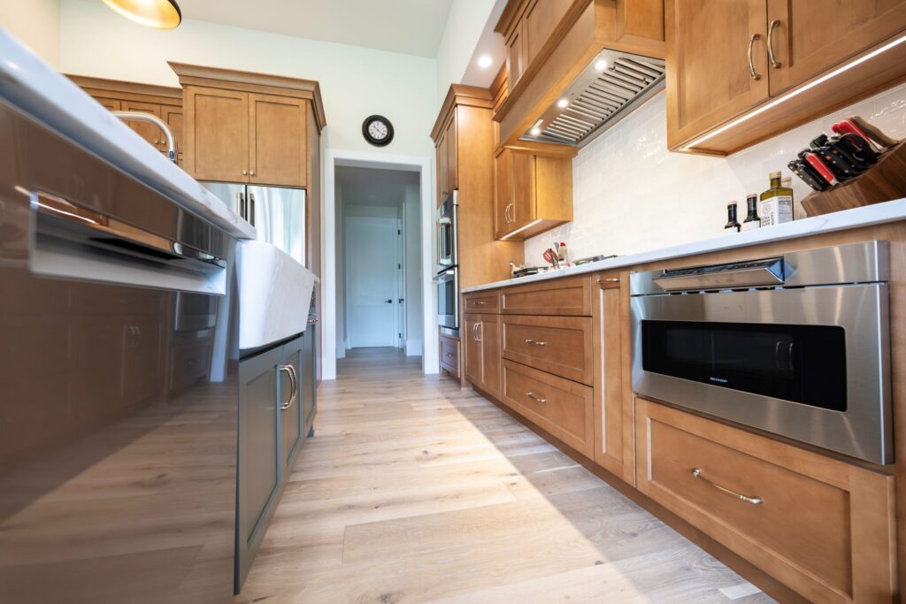 A view of the premium white farm sink and Moen faucet integrated into a custom painted kitchen island.