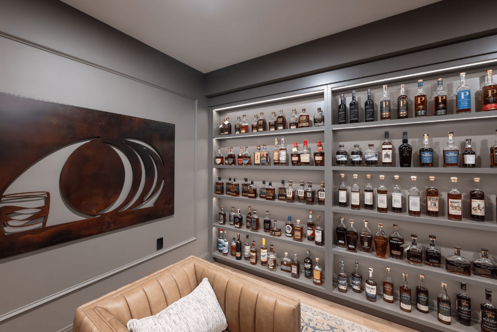 A view of the completed whiskey bar in Center Valley, PA featuring paint grade maple illuminated shelving with custom millwork.