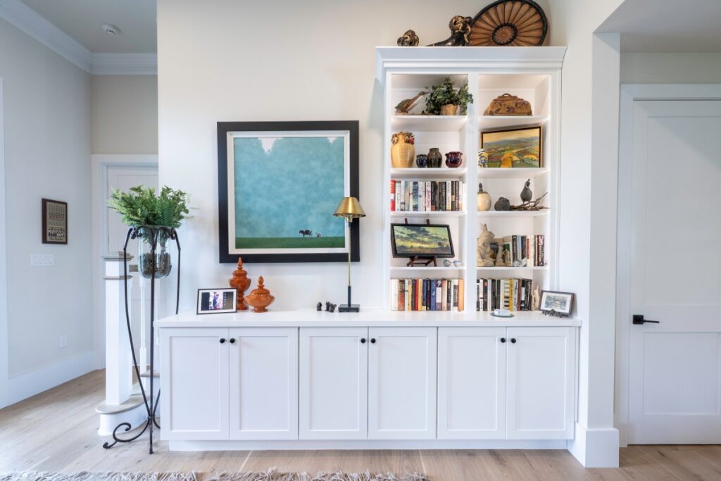 Bethlehem built-in bookcase with open shelves, concealed base cabinets, and space for framed artwork beside the staircase.