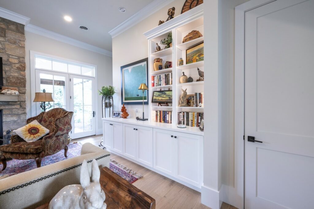 Built-in bookcase in a Bethlehem living area with illuminated display shelves and six doors for concealed storage.
