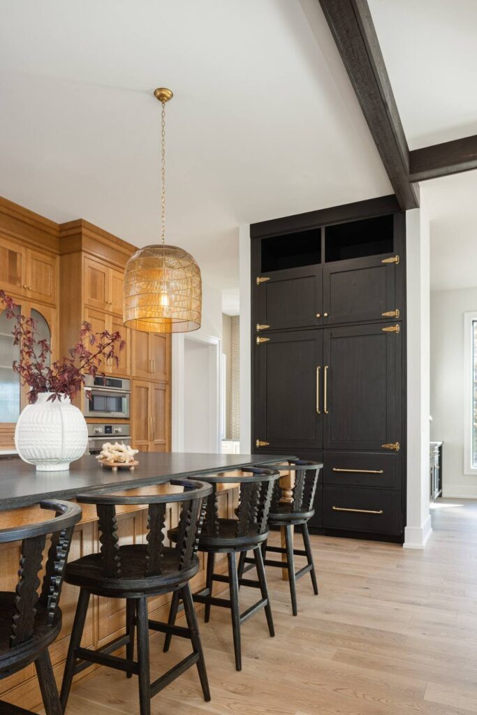 Dark distressed alder refrigerator cabinetry beside a quarter-sawn white oak kitchen island.