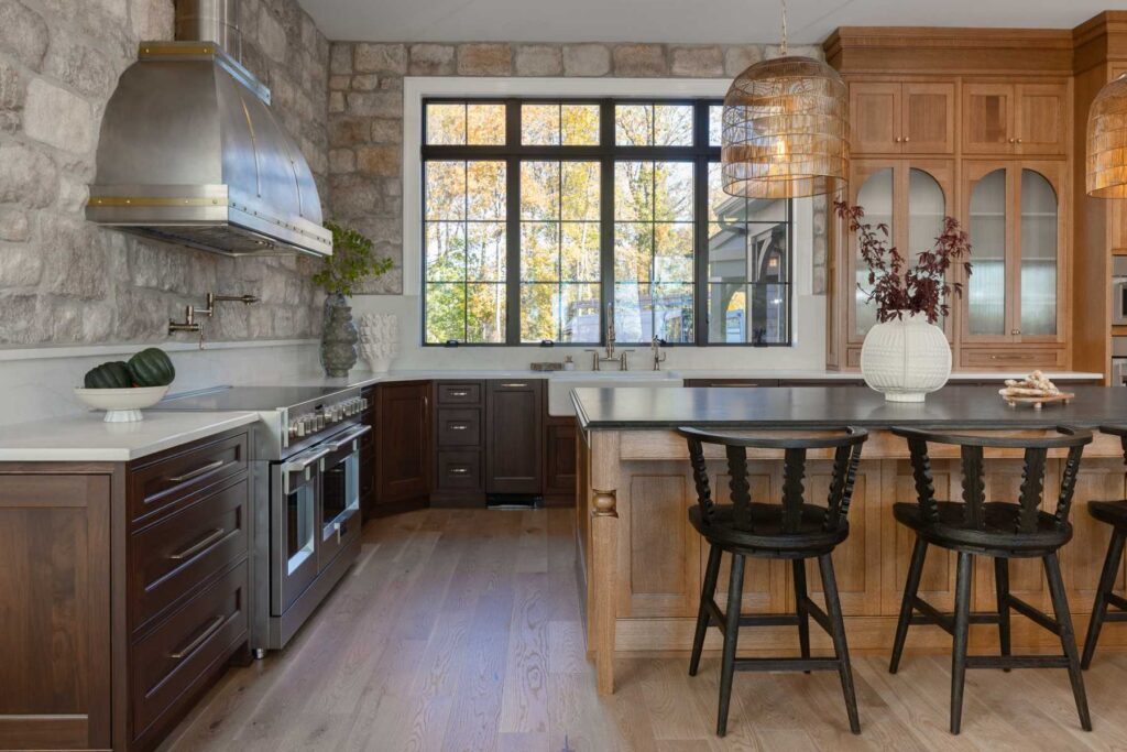Walnut kitchen cabinets beside a stainless steel range, farm sink, stone backsplash, and white oak island in Emmaus.