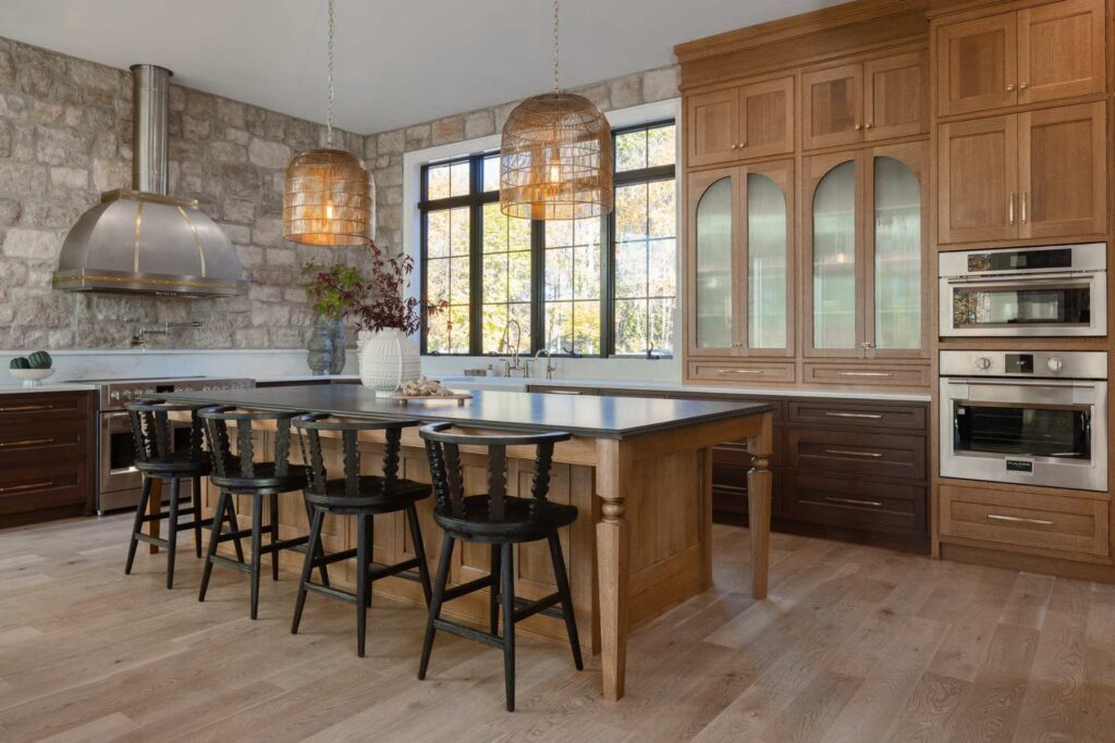 Emmaus kitchen with walnut base cabinets, quarter-sawn white oak island, arched glass doors, and integrated wall ovens.