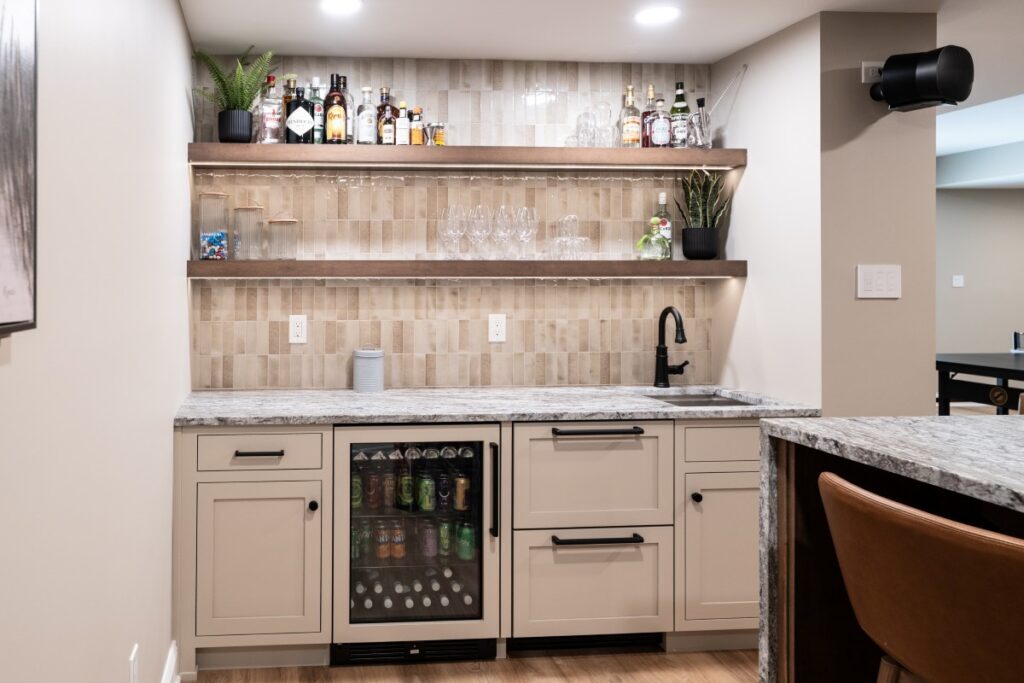 Center Valley wet bar with Tyler Gray flush inset cabinetry, Blue Dunes granite, beverage refrigeration, sink, and illuminated floating shelves.