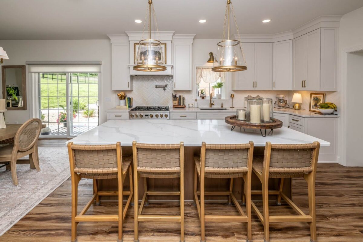 White kitchen in Hellertown, PA with a large natural wood island, seating for four, and pendant lighting.