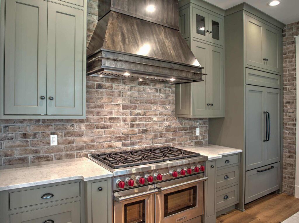 Custom kitchen in Orefield, PA with painted cabinetry, a professional-style range, statement metal hood, and cabinetry designed around the appliances.