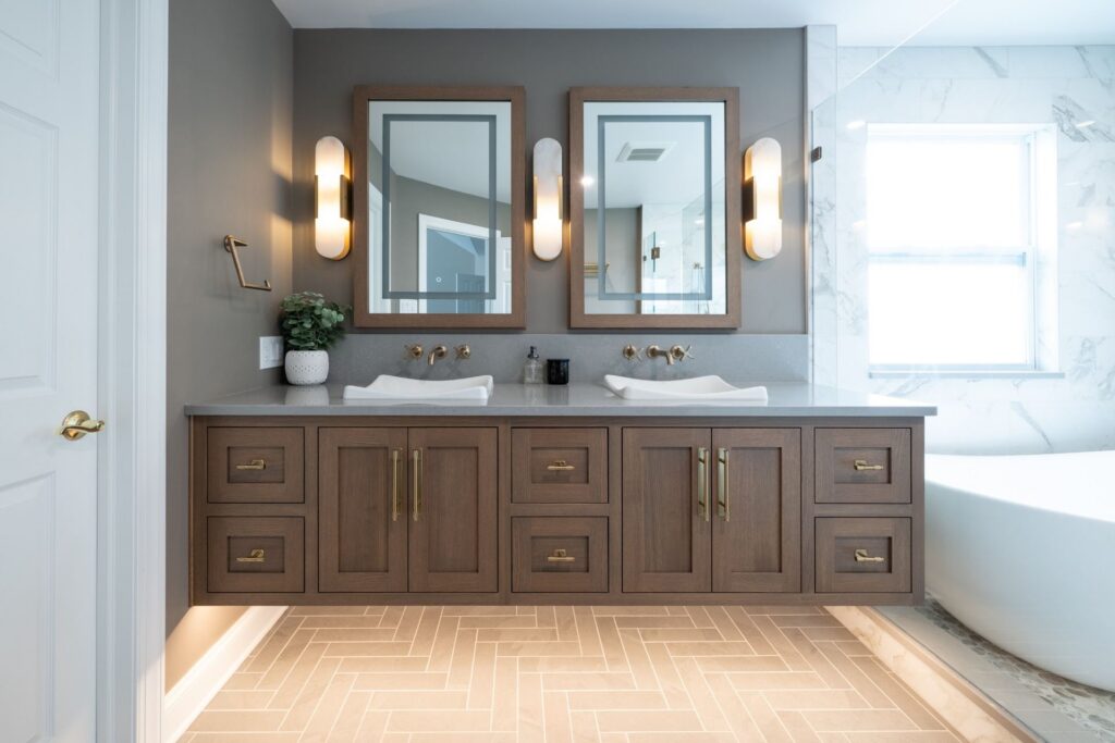 Rift Cut White Oak flush inset double vanity in Sesame stain with quartz countertops, white vessel sinks, framed mirrors, and wall sconces.
