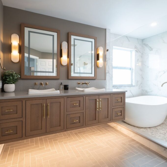 Easton primary bathroom with a Sesame-stained Rift Cut White Oak double vanity, vessel sinks, freestanding tub, and glass shower partition.