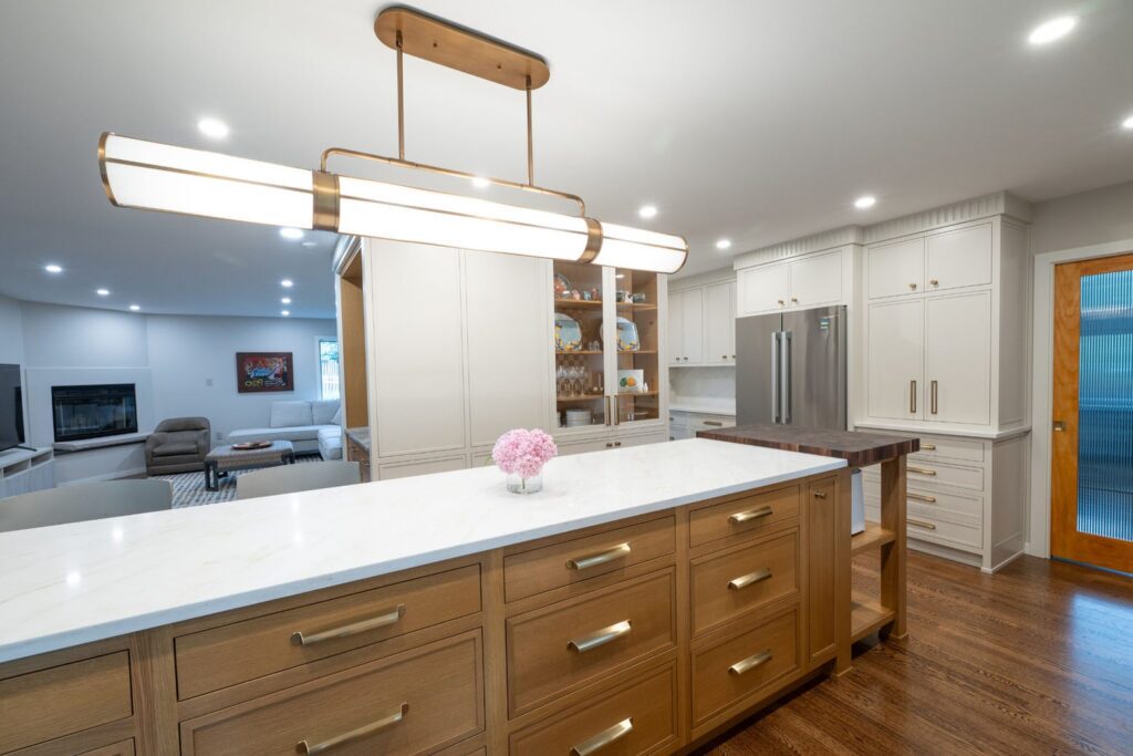 Custom-stained rift cut white oak kitchen island with inset drawers and cup pulls beneath a quartz countertop.