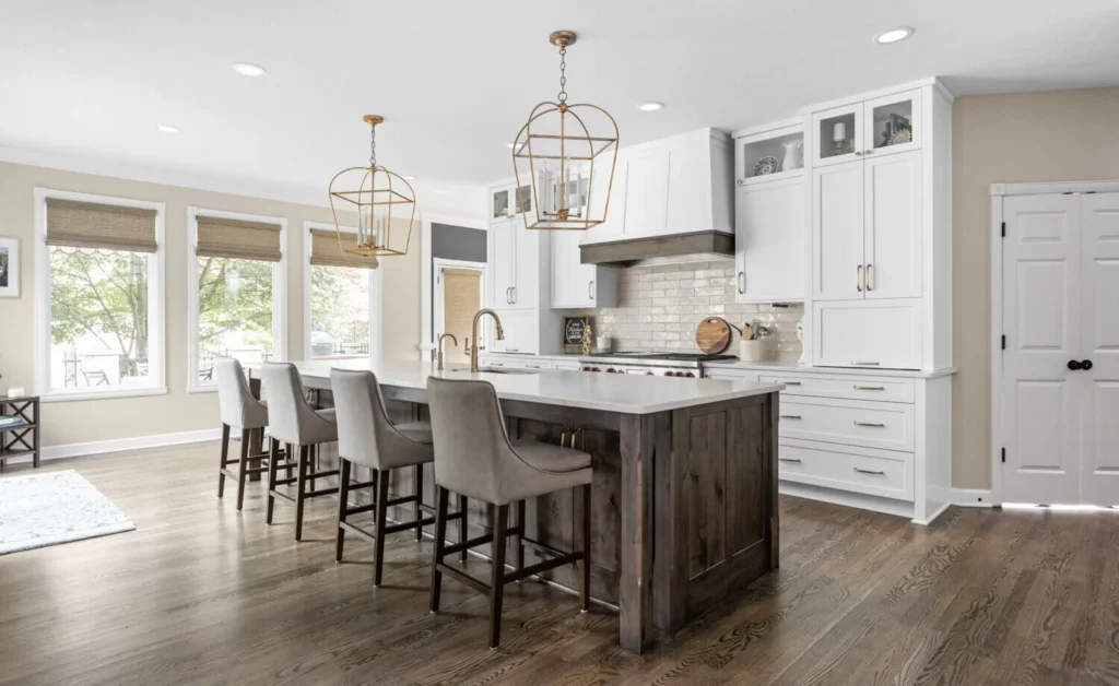 A kitchen with white cabinets and a gray island.