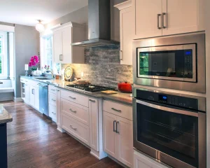 A kitchen with white cabinets and stainless steel appliances