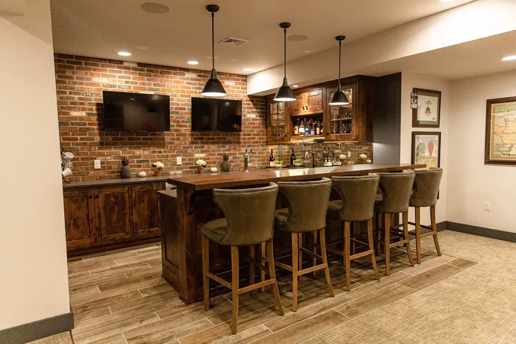 A place for guests to watch TV or football games that is rustic and has custom cabinetry and lighting.