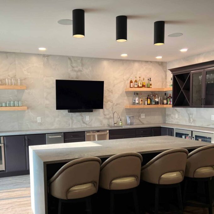 basement bar remodel in bath pa with floating shelves and a seating island for tv viewing